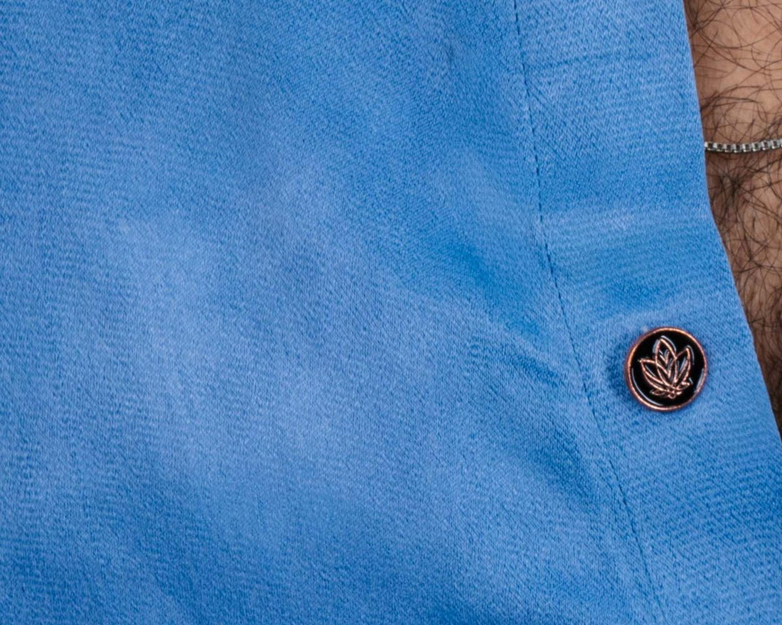 The Mula lotus button on a blue shirt